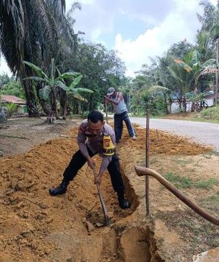 Bhabinkamtibmas Polsek Kerumutan Ikut Gotong Royong, Sampaikan Pesan Damai Pilkada